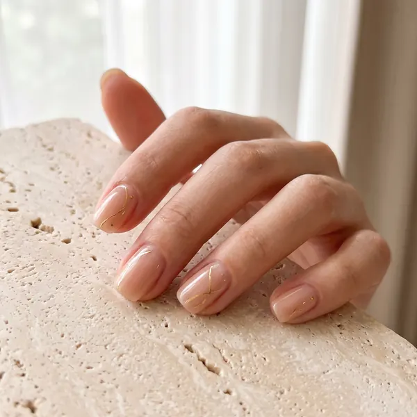 Minimal nail art with fine gold-foil lines